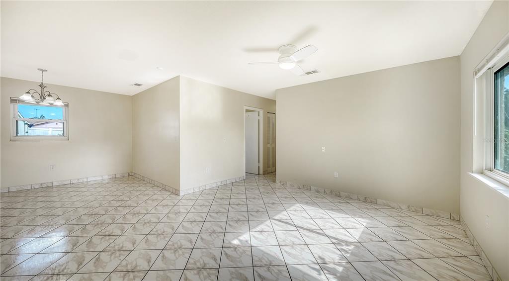 A single-story house with a tan exterior, a front carport, and a large grassy yard — 3307 NEWTOWN BOULEVARD, SARASOTA, FL
