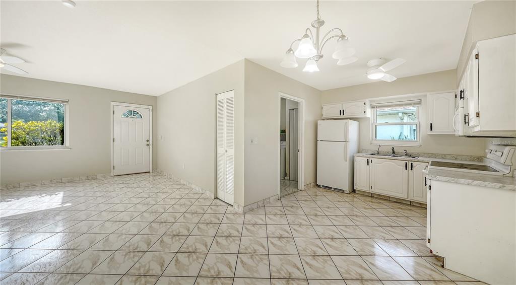 A single-story house with a tan stucco exterior, a front carport, and a grassy lawn — 3307 NEWTOWN BOULEVARD, SARASOTA, FL