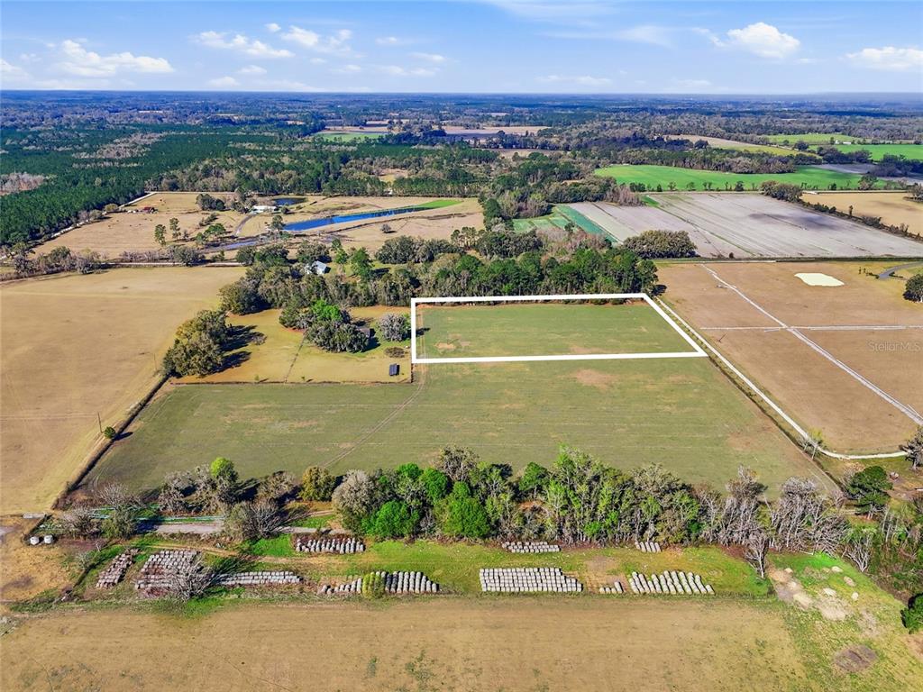An aerial view shows a rectangular plot of land outlined in white within a field — TBD NW COUNTY RD 239, ALACHUA, FL