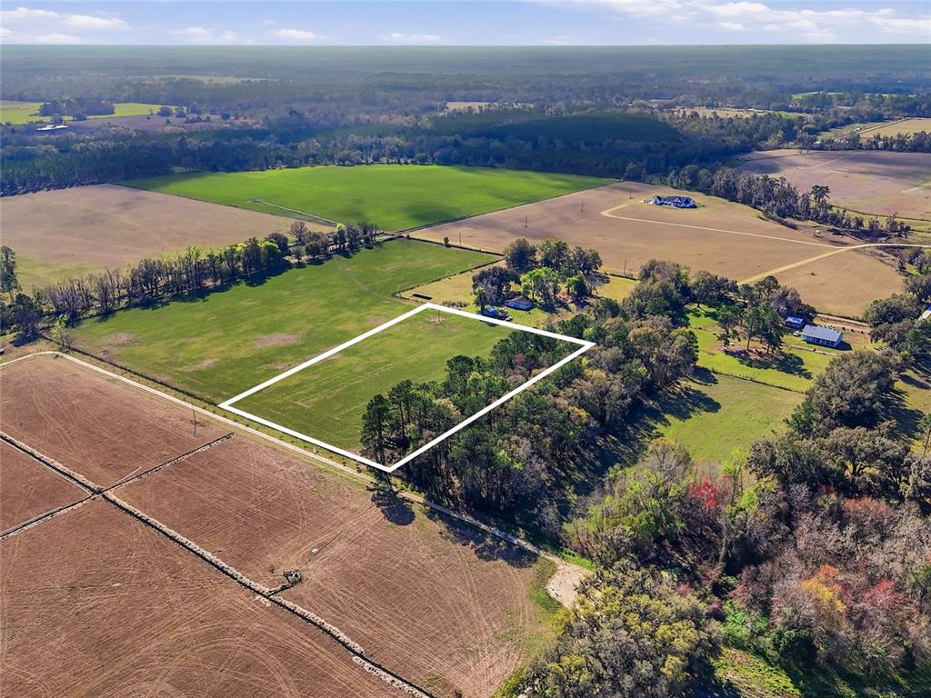 An aerial view shows a rectangular plot of land outlined in white within a field — TBD NW COUNTY RD 239, ALACHUA, FL