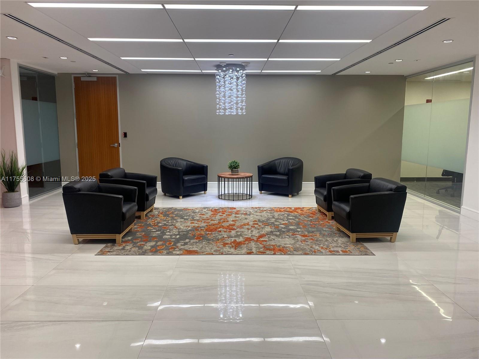 A modern office lobby features a seating area with four black armchairs and a rug — 2 S Biscayne Blvd # 3200, Miami FL 33131, MIAMI, FL