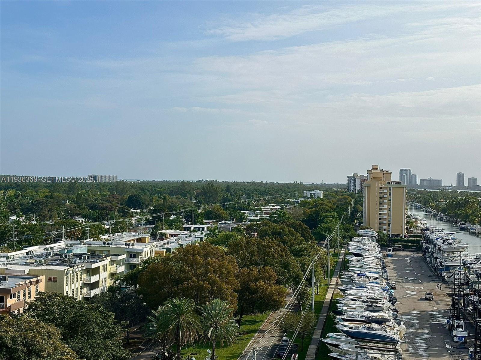 An elevated view shows a boat storage yard, residential buildings, and lush trees under a sky — 13499 Biscayne Blvd # 1013, North Miami FL 33181, NORTH MIAMI, FL