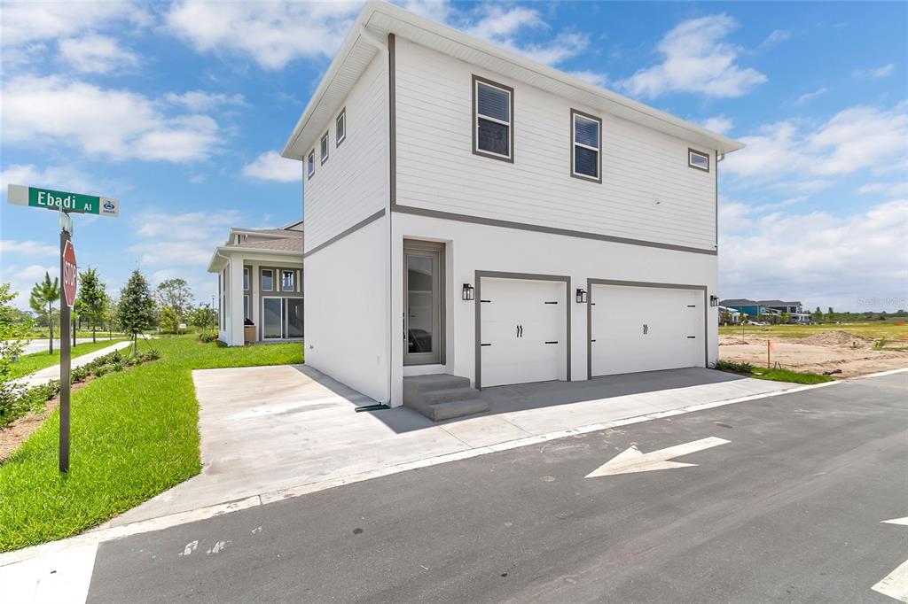 A two-story white house with a two-car garage and a side entrance on a corner lot — 9687 MACBRIDE DRIVE, ORLANDO, FL