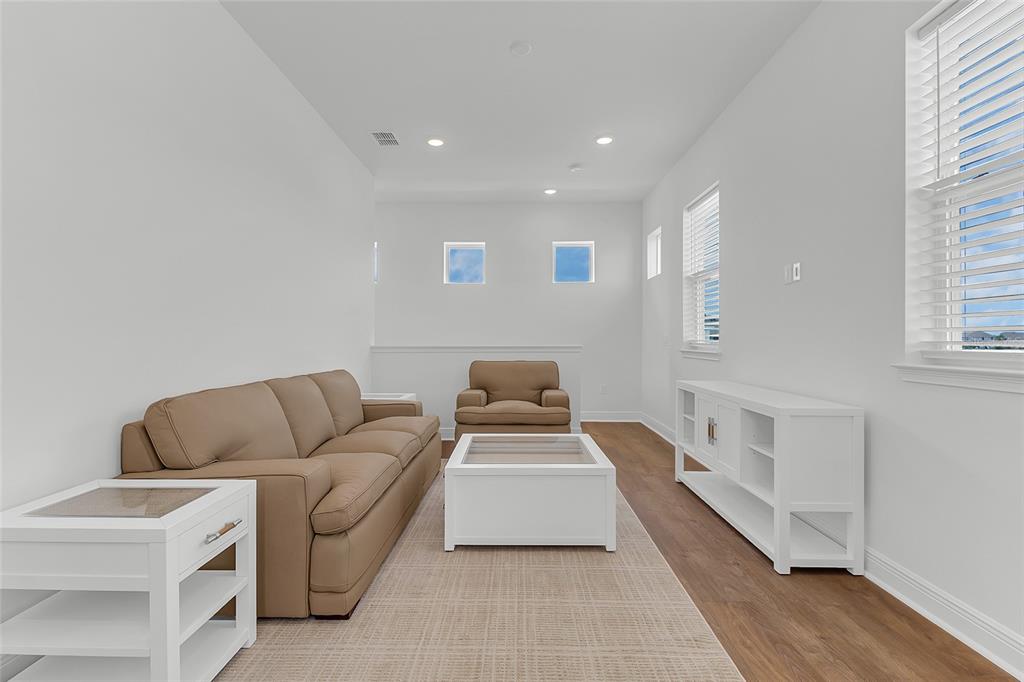 A living room features a tan sofa, a white coffee table, and white media console — 9687 MACBRIDE DRIVE, ORLANDO, FL