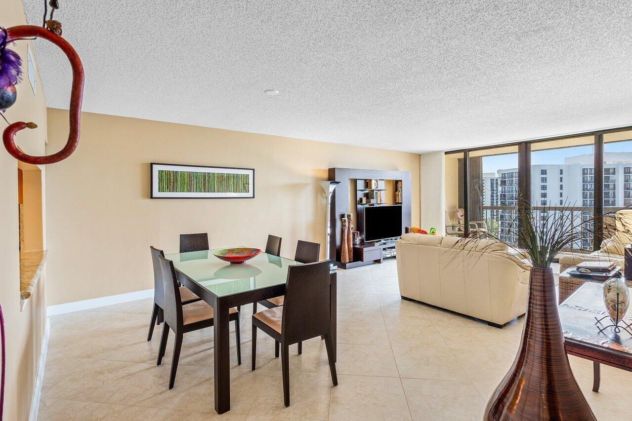 A dining area and living room with tile floors, a glass table, and floor-to-ceiling windows — 4740 S Ocean Boulevard # 1515, Highland Beach FL 33487, HIGHLAND BEACH, FL