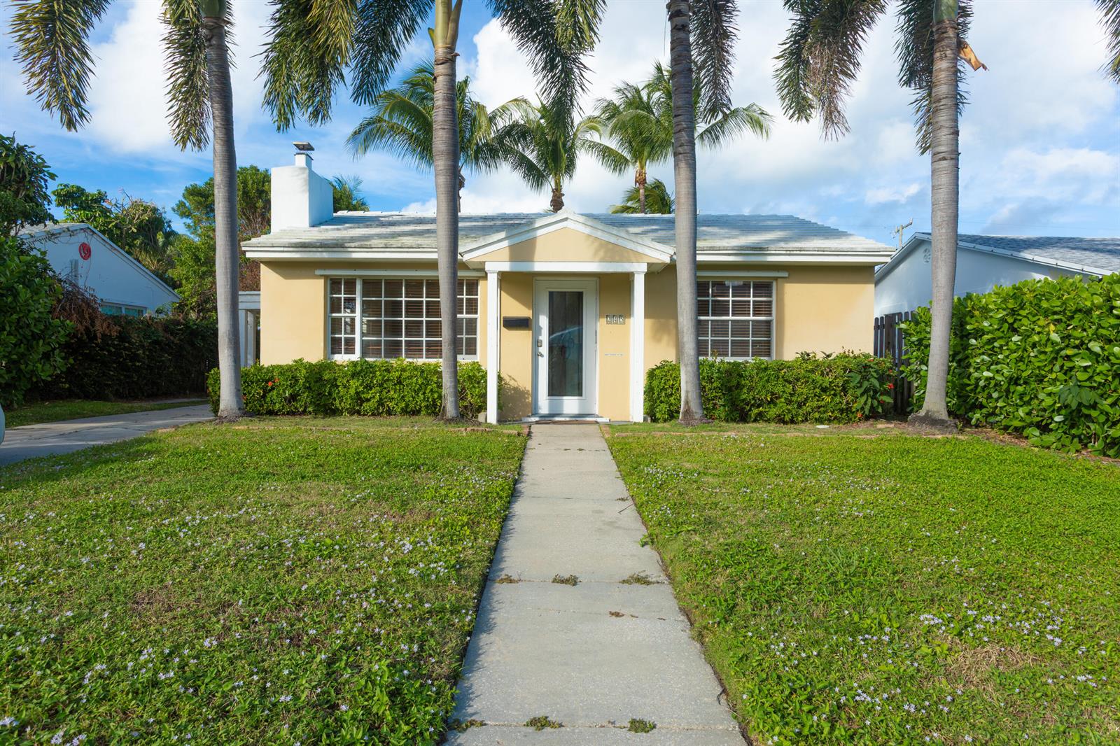 A single-story yellow house with a white front door and palm trees in the yard — 245 Cortez Road, West Palm Beach FL 33405, WEST PALM BEACH, FL