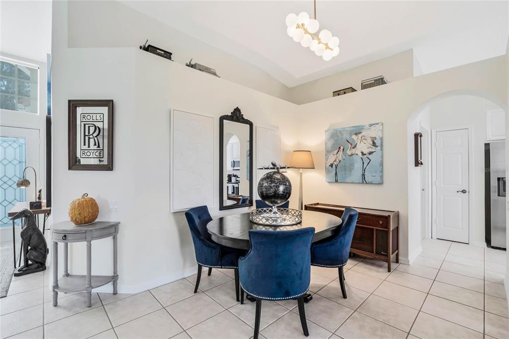 A dining area features a round table with blue velvet chairs and a globe centerpiece — 4713 WINDSOR AVENUE, ORLANDO, FL