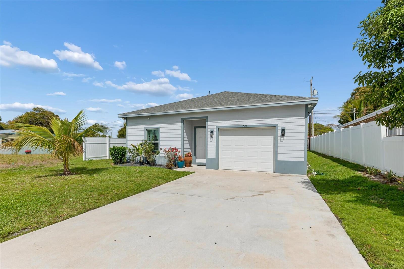 A single-story house with light gray siding, a white garage door, and a concrete driveway — 525 NW 12th Avenue, Boynton Beach FL 33435, BOYNTON BEACH, FL