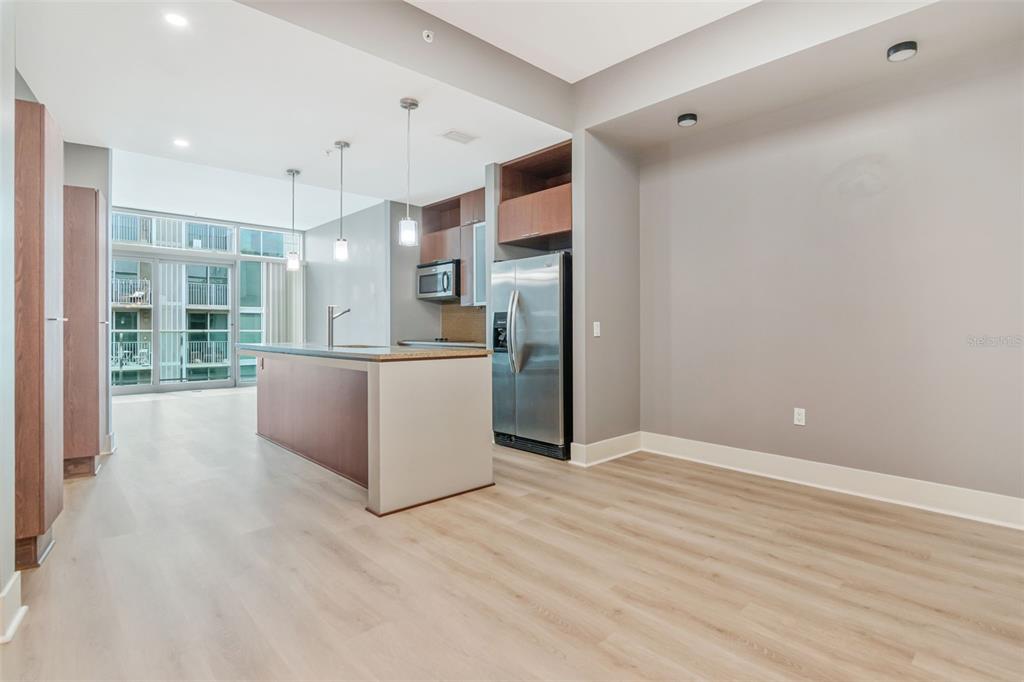 A kitchen with a center island, stainless steel refrigerator, and light wood-look flooring — 111 N 12TH STREET UNIT 1820, TAMPA, FL