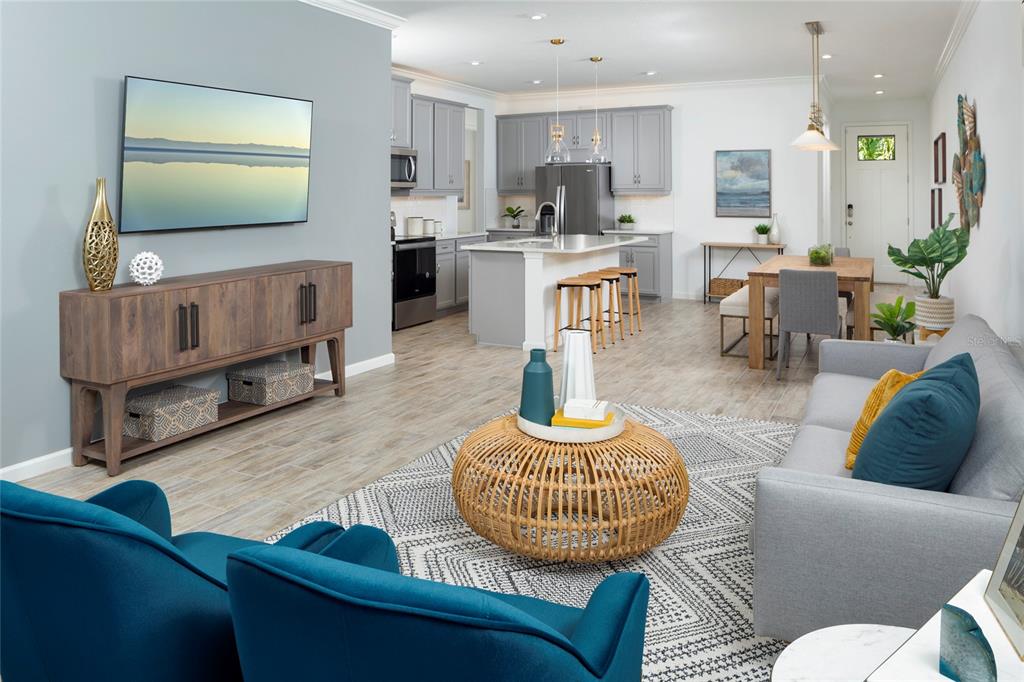 An open-concept living room and kitchen featuring gray cabinets, a kitchen island, and blue furniture — 11910 MANDALA COURT, VENICE, FL