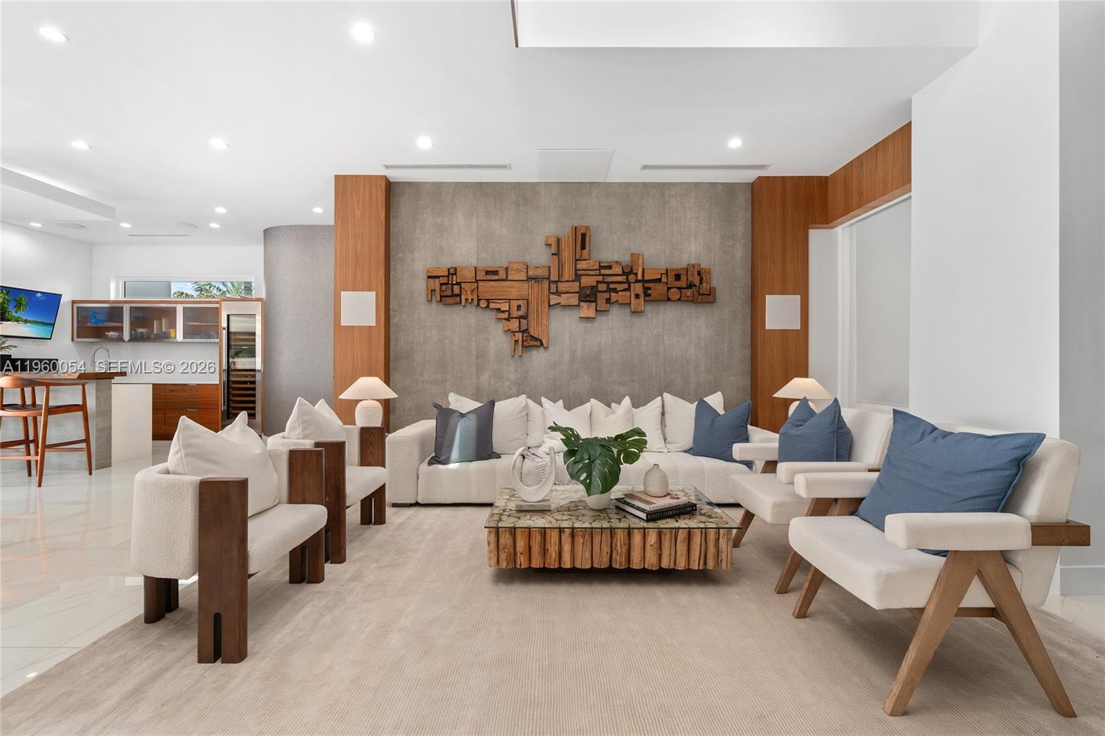 A modern living room features a textured gray accent wall, wooden wall panels, and neutral furniture — 12880 N Bayshore Dr, North Miami FL 33181, NORTH MIAMI, FL