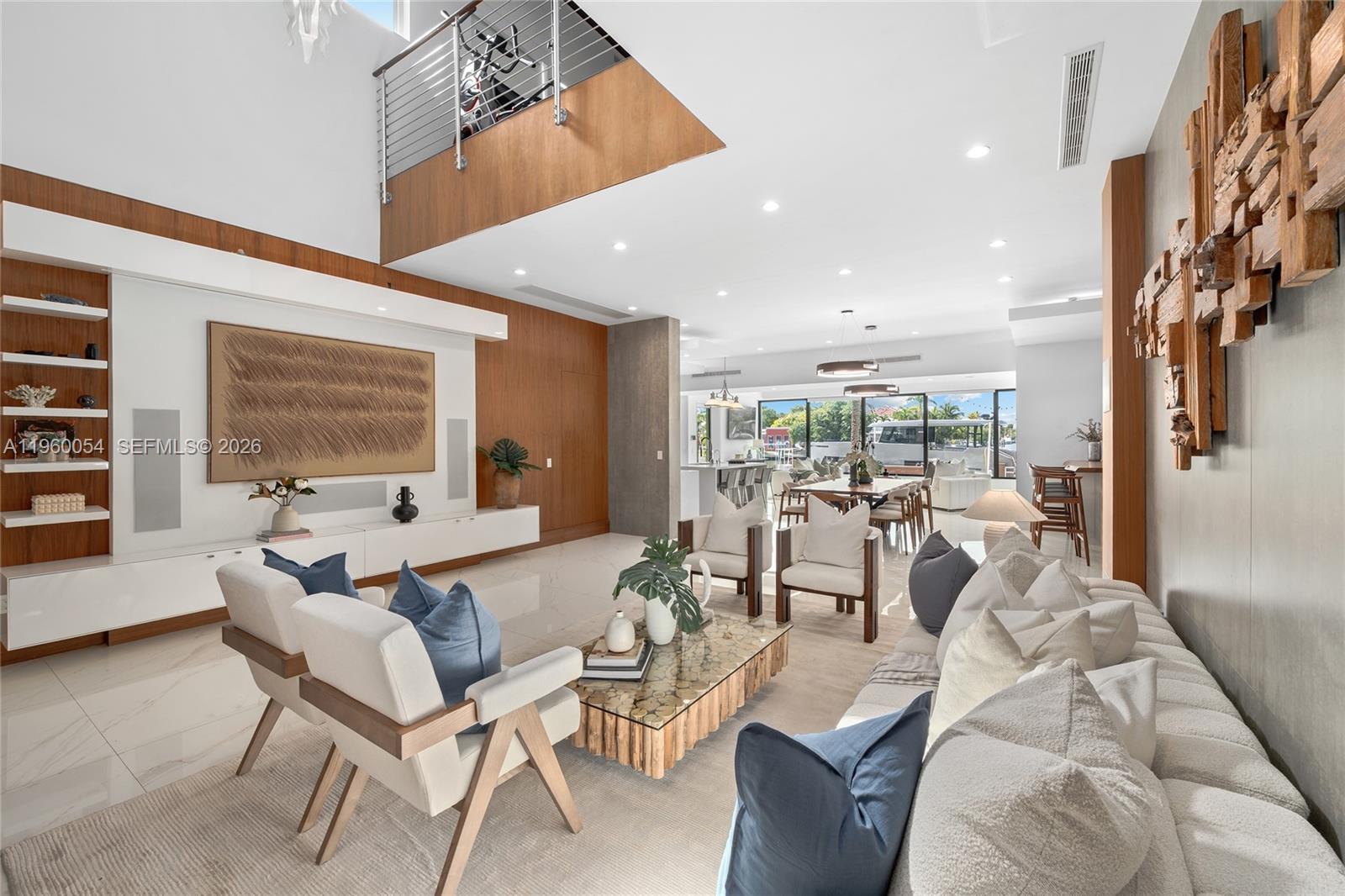 A modern living room features white tile floors, a wooden mezzanine, and textured wall art — 12880 N Bayshore Dr, North Miami FL 33181, NORTH MIAMI, FL