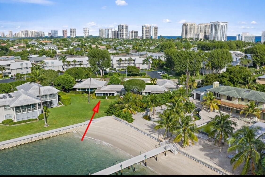 An aerial view of a waterfront property with a sandy beach, dock, and lush landscaping — 1145 Sugar Sands Boulevard, Singer Island FL 33404, SINGER ISLAND, FL