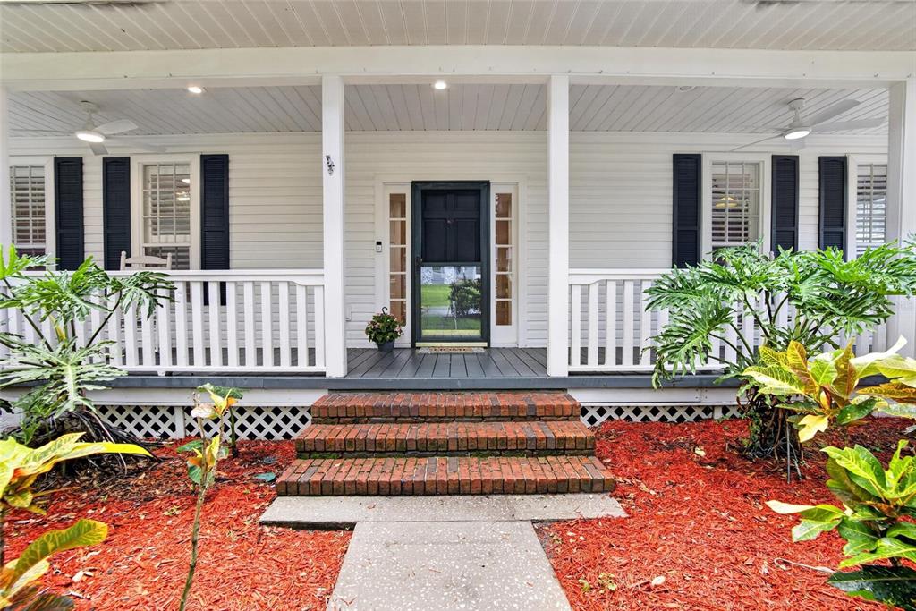 A front porch with white railings, brick steps, and black shutters on a white house — 1701 COTTAGE OAKS COURT, BRANDON, FL