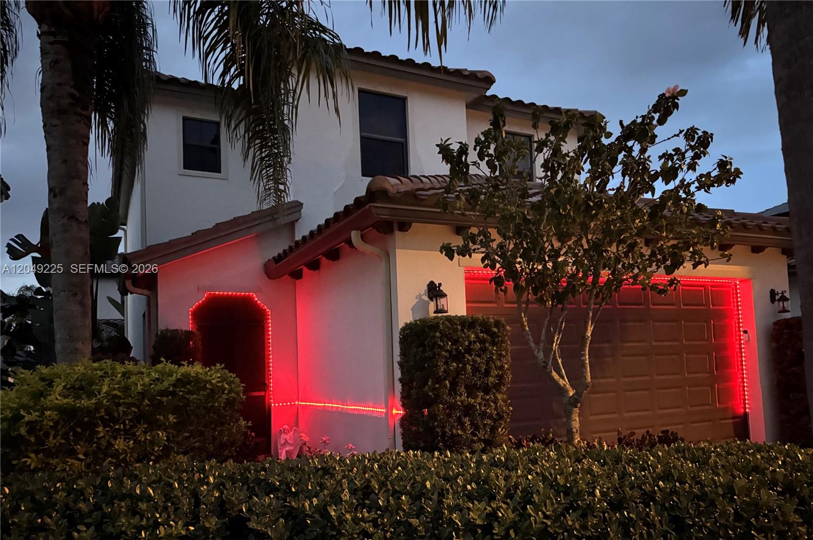 A brick walkway leads to a screened front door surrounded by lush landscaping and hedges — 5434 USEPPA DR, Ave Maria FL 34142, AVE MARIA, FL