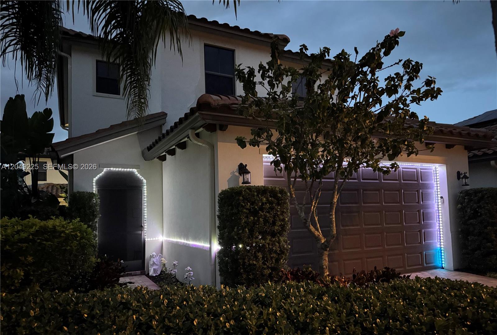 A white front door opens into a small entryway with tiled flooring and wall art — 5434 USEPPA DR, Ave Maria FL 34142, AVE MARIA, FL