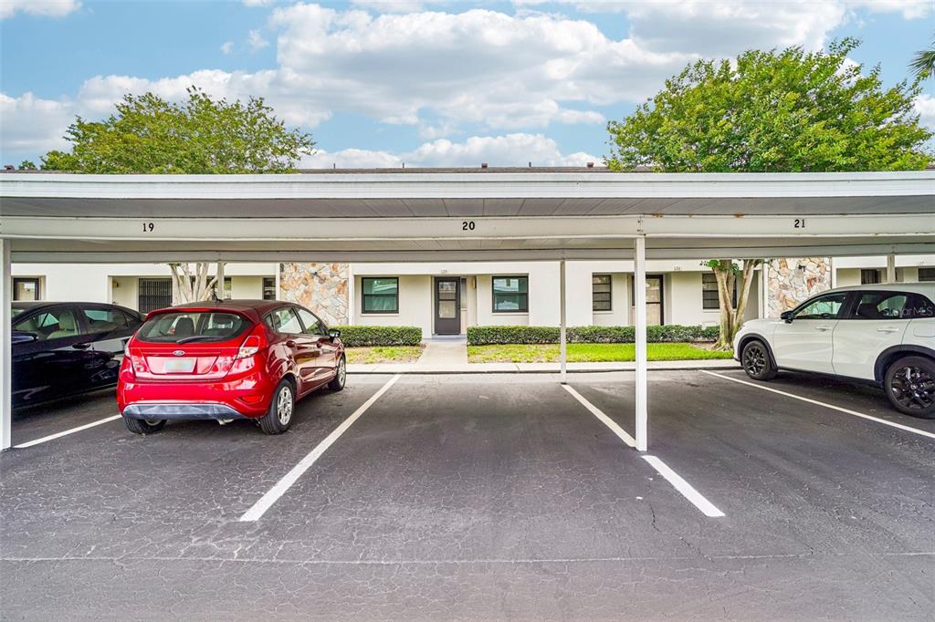 A covered parking area features numbered spaces in front of a multi-unit residential building — 1601 43RD STREET N UNIT 224, ST PETERSBURG, FL