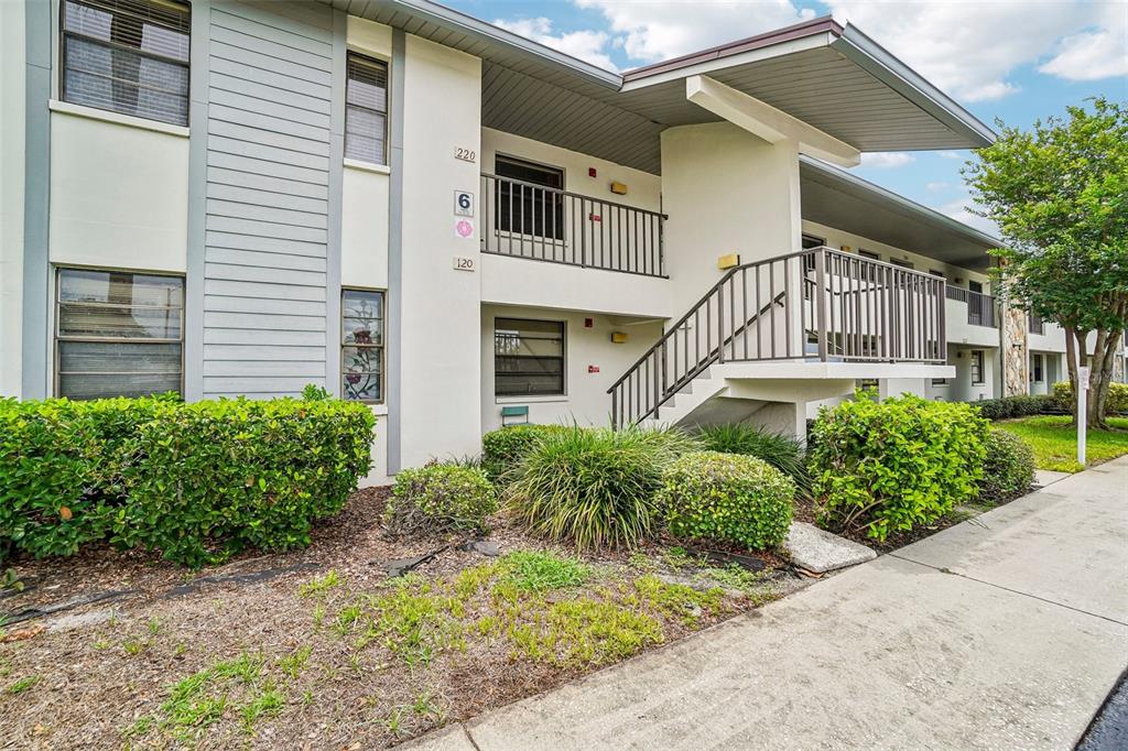 An exterior view of a two-story apartment building with a staircase and metal railings — 1601 43RD STREET N UNIT 224, ST PETERSBURG, FL