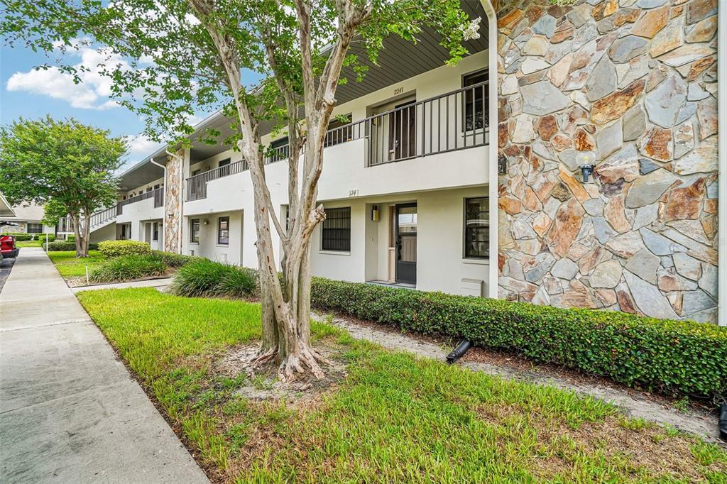 A two-story apartment building features a stone facade, white walls, and a concrete walkway — 1601 43RD STREET N UNIT 224, ST PETERSBURG, FL