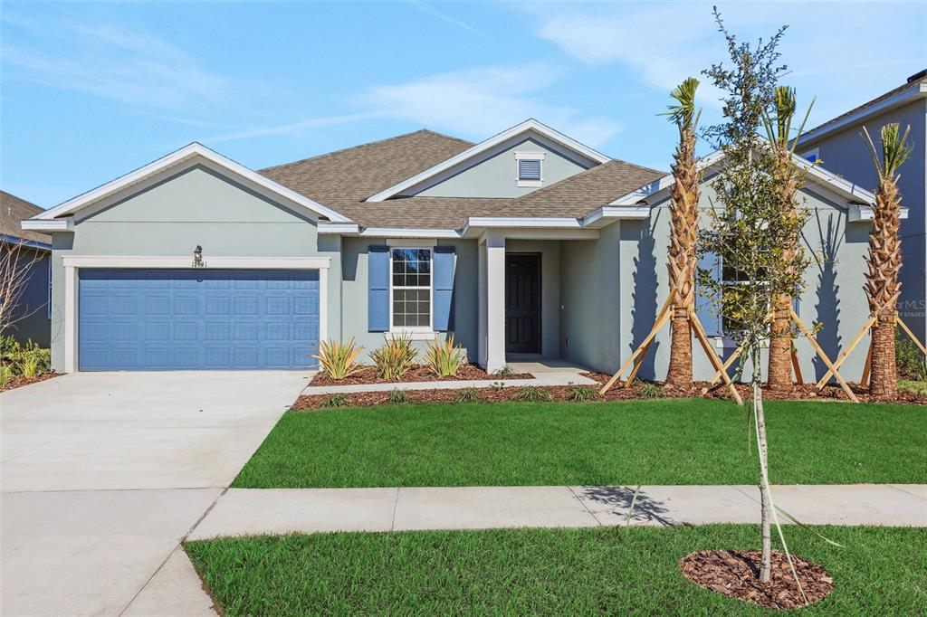 A living room features a large sectional sofa, a wooden coffee table, and sliding glass doors — 17441 VALLEYWOOD PARKWAY, LAND O LAKES, FL