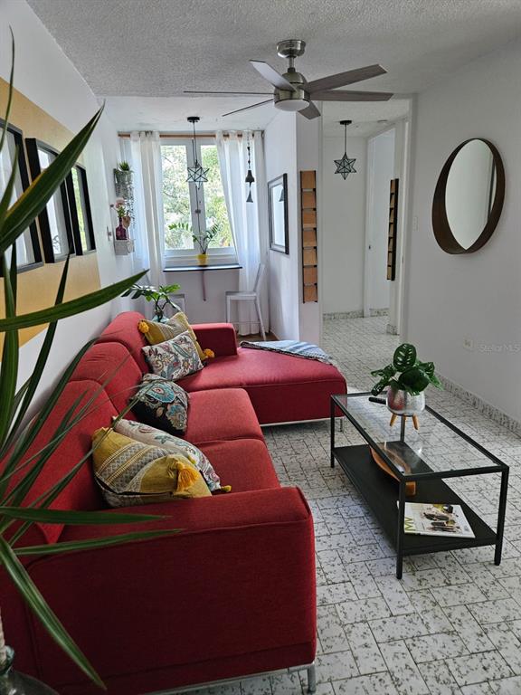 A living room features a red sectional sofa, a glass coffee table, and a window nook — 78 NE KINGS COURT COMMON UNIT 2-A, SAN JUAN, PR