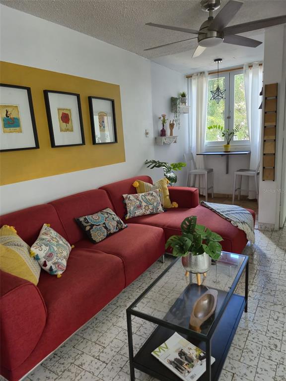 A living room features a red sectional sofa, a glass coffee table, and a dining nook — 78 NE KINGS COURT COMMON UNIT 2-A, SAN JUAN, PR