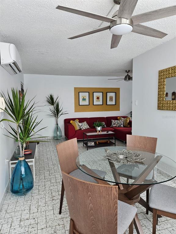 A dining area with a glass table leads into a living room with a red sofa — 78 NE KINGS COURT COMMON UNIT 2-A, SAN JUAN, PR