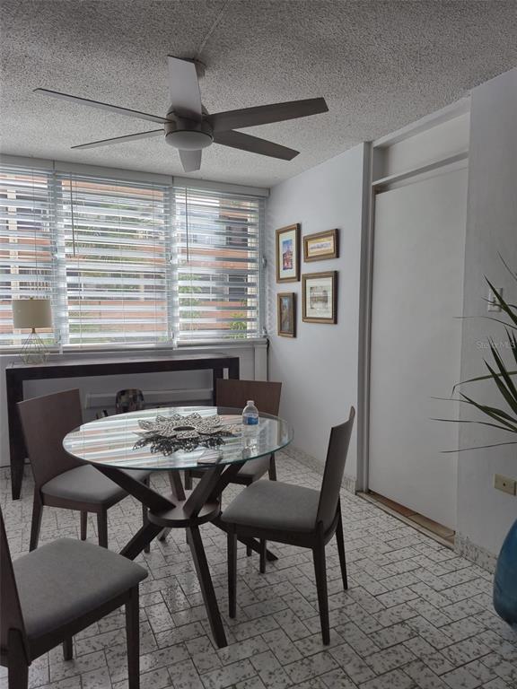 A sunroom features a glass-topped dining table, four chairs, tiled flooring, and a ceiling fan — 78 NE KINGS COURT COMMON UNIT 2-A, SAN JUAN, PR