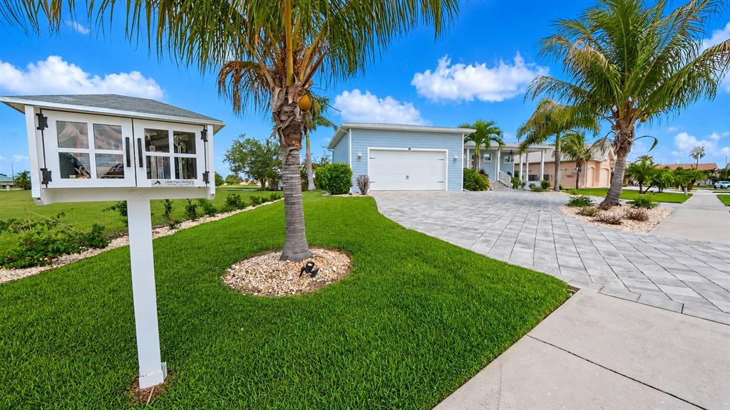 A small wooden library box stands in the front yard of a suburban home — 3845 BAL HARBOR BOULEVARD, PUNTA GORDA, FL