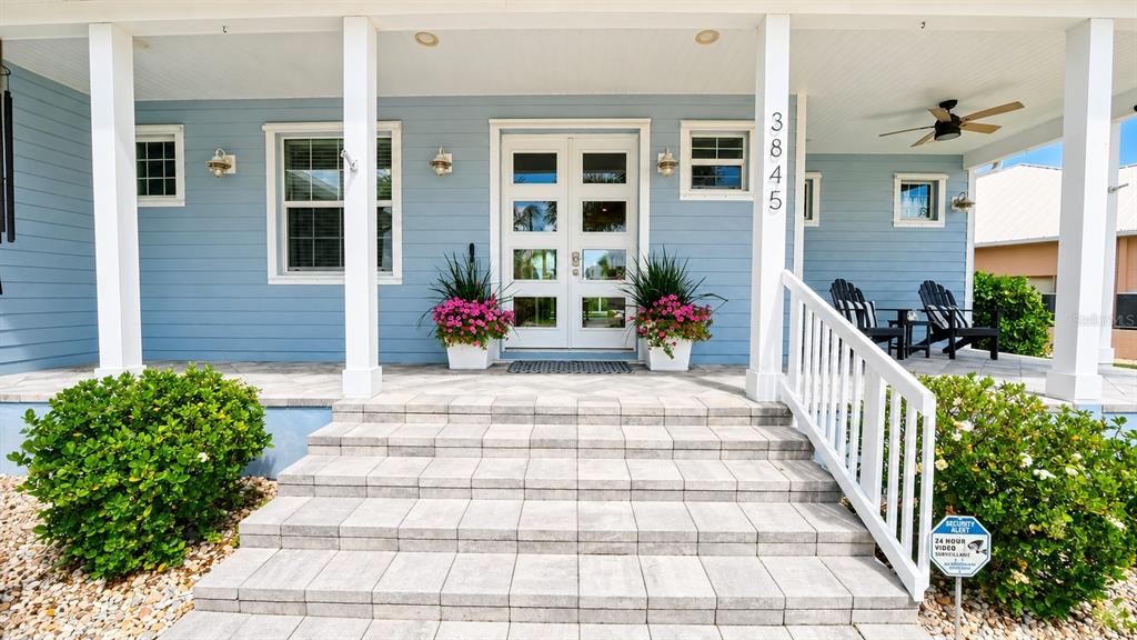 A blue house exterior features a front porch with stone steps and double glass doors — 3845 BAL HARBOR BOULEVARD, PUNTA GORDA, FL