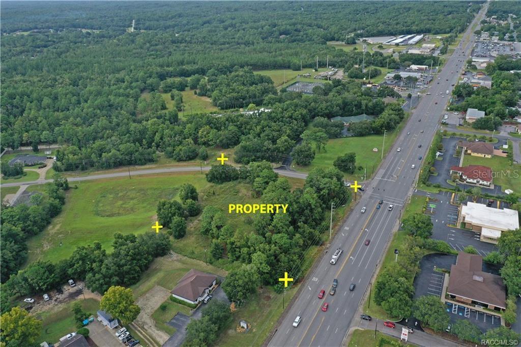 An aerial view shows a vacant, tree-lined lot situated next to a multi-lane highway — 2314 W PERCHWOOD DRIVE, BEVERLY HILLS, FL