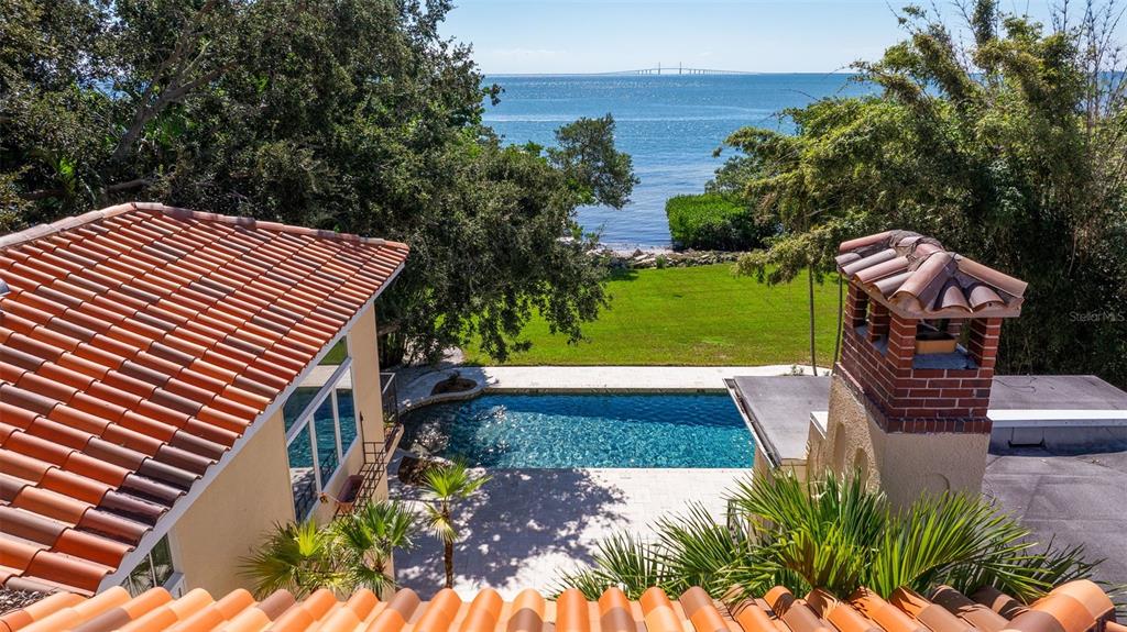 An elevated view of a backyard pool, lawn, and waterfront with a bridge in distance — 7240 DR MARTIN LUTHER KING JR STREET S, ST PETERSBURG, FL
