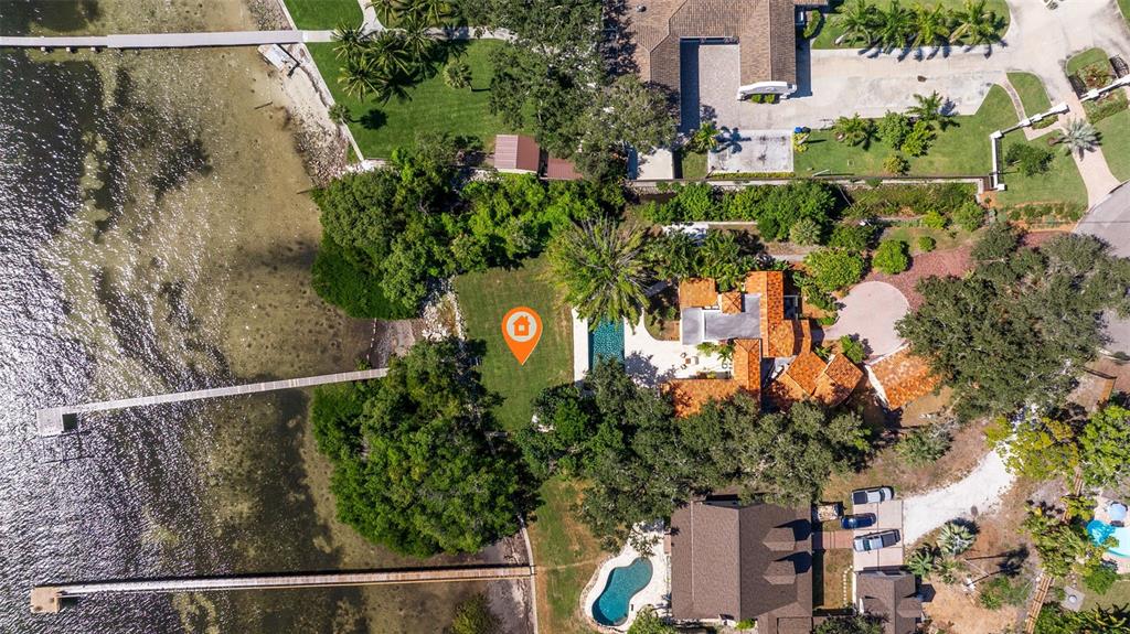 An aerial view shows a waterfront property with two houses, swimming pools, and long docks — 7240 DR MARTIN LUTHER KING JR STREET S, ST PETERSBURG, FL