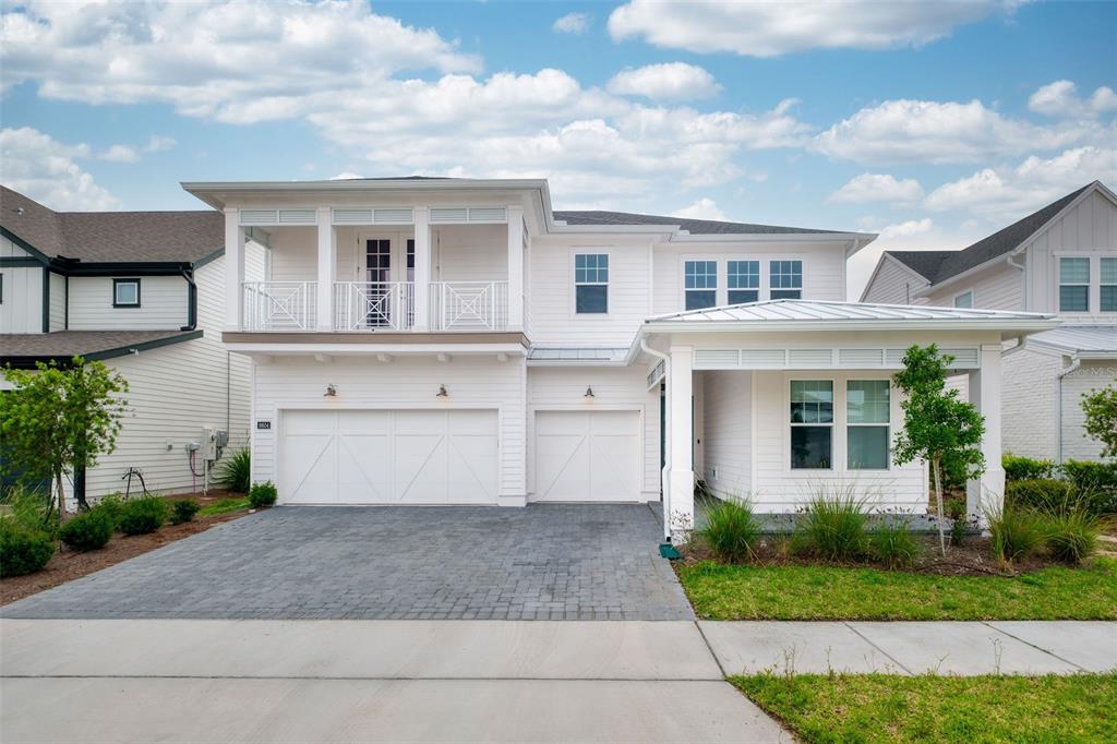 A two-story white house with a three-car garage and a front porch — 6604 QUEST STREET, ST CLOUD, FL
