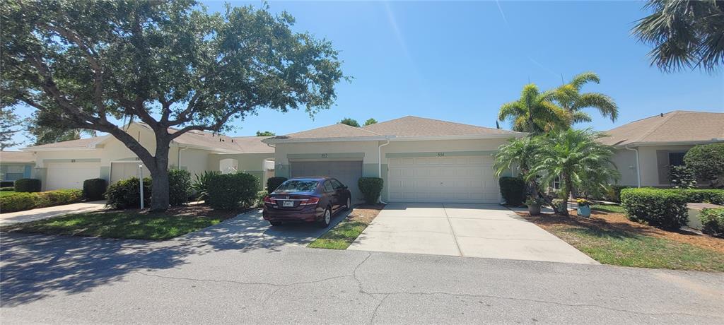 A street-level view shows two attached single-story houses with garages and a parked car — 834 TREMONT GREENS LANE UNIT 137, SUN CITY CENTER, FL