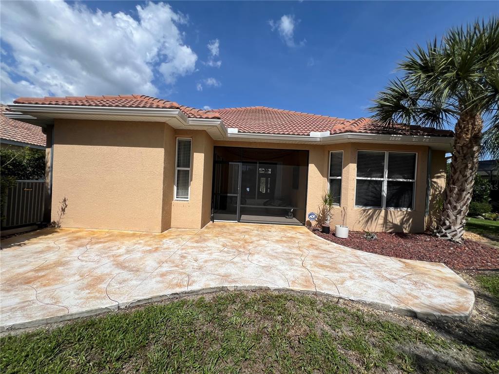 A rear view of a house with a stamped concrete patio and a screened-in porch — 2344 CARAWAY DRIVE, VENICE, FL