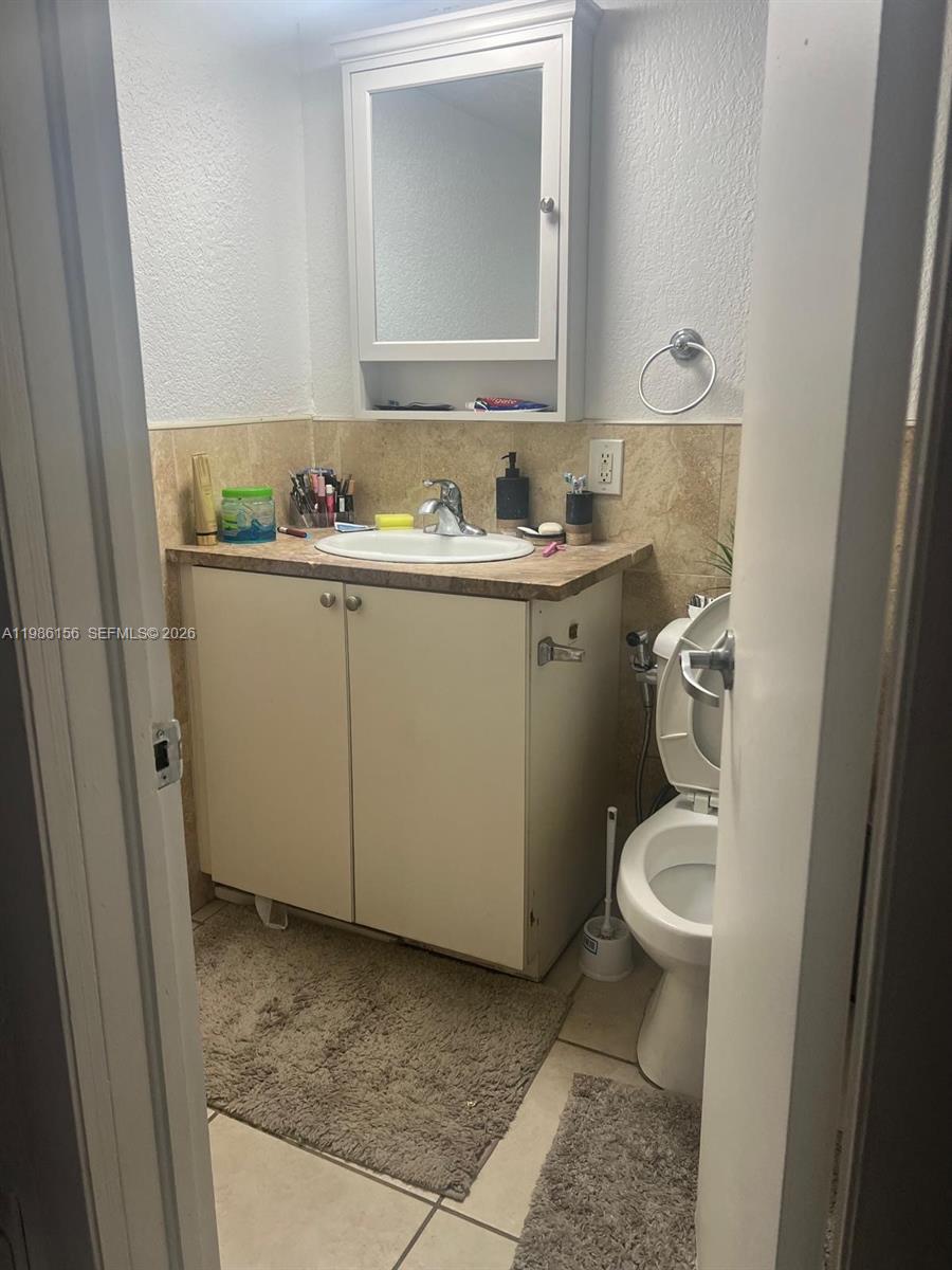 A small bathroom features a vanity with a sink, a medicine cabinet, and a toilet — 3901 SW 112th Ave # 34, Miami FL 33165, MIAMI, FL