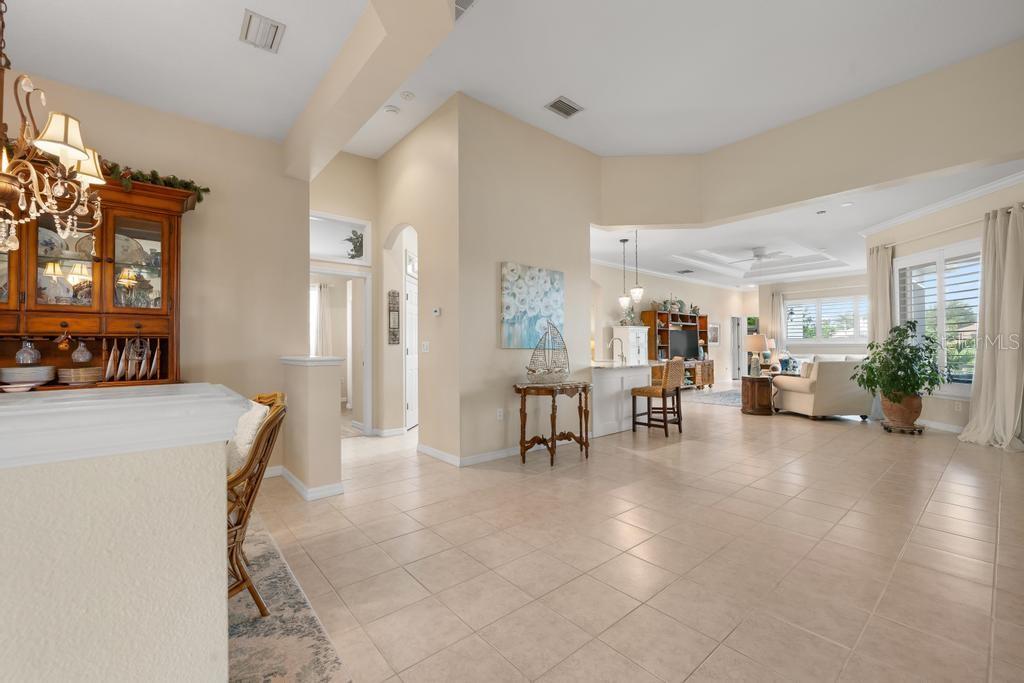 An open-concept living area features tile flooring, a dining hutch, and a kitchen island — 264 DAHLIA COURT, BRADENTON, FL