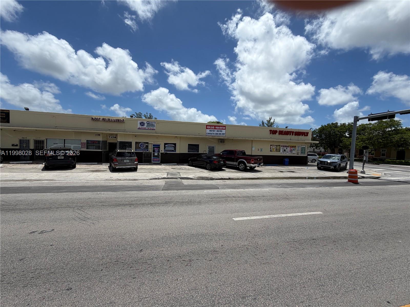A single-story commercial strip mall with parking spaces in front under a blue sky — 7509 NW 22nd Ave, Miami FL 33147, MIAMI, FL