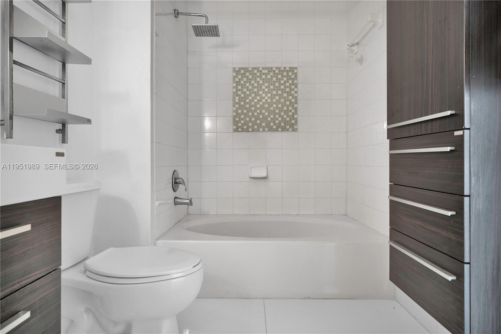 A bathroom features a white bathtub, a toilet, and dark wood cabinetry — 2001 Biscayne Blvd # 3213, Miami FL 33137, MIAMI, FL
