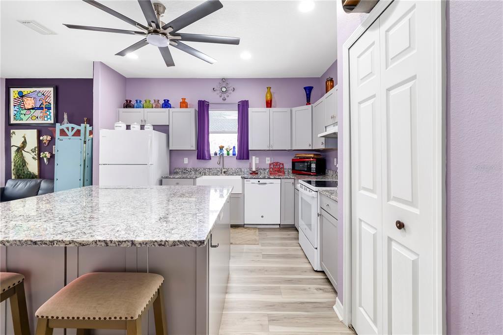 A kitchen with light gray cabinets, granite countertops, a large island, and purple walls — 2434 BISMARCK ROAD, NORTH PORT, FL