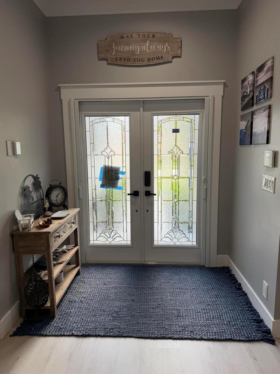 An entryway features a double glass-paneled door, a wooden console table, and a dark rug — 3755 Spring Crest Court, Lake Worth FL 33467, LAKE WORTH, FL