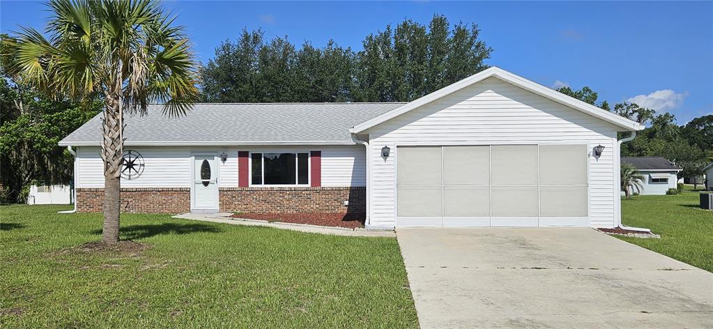 A single-story house with white siding, a brick base, and a large attached garage — 10854 SW 78TH COURT, OCALA, FL