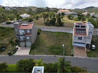 An aerial view shows a vacant residential lot situated between two multi-story houses — MARINA VIEW 5 UNIT 5, HUMACAO, PR