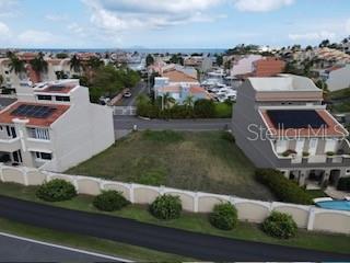 An aerial view shows a vacant residential lot situated between two multi-story houses near the water — MARINA VIEW 5 UNIT 5, HUMACAO, PR