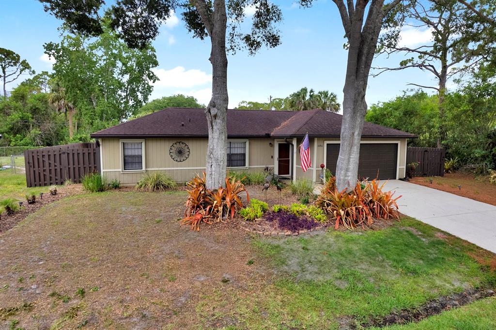 A single-story house with a brown roof, tan siding, and a two-car garage — 1080 HAMMACHER AVENUE SW, PALM BAY, FL