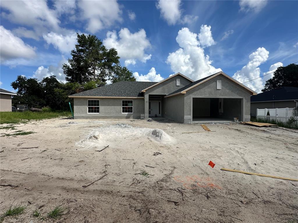A newly constructed single-story house with a stucco exterior and an attached two-car garage — 8 DOGWOOD PLACE, OCALA, FL