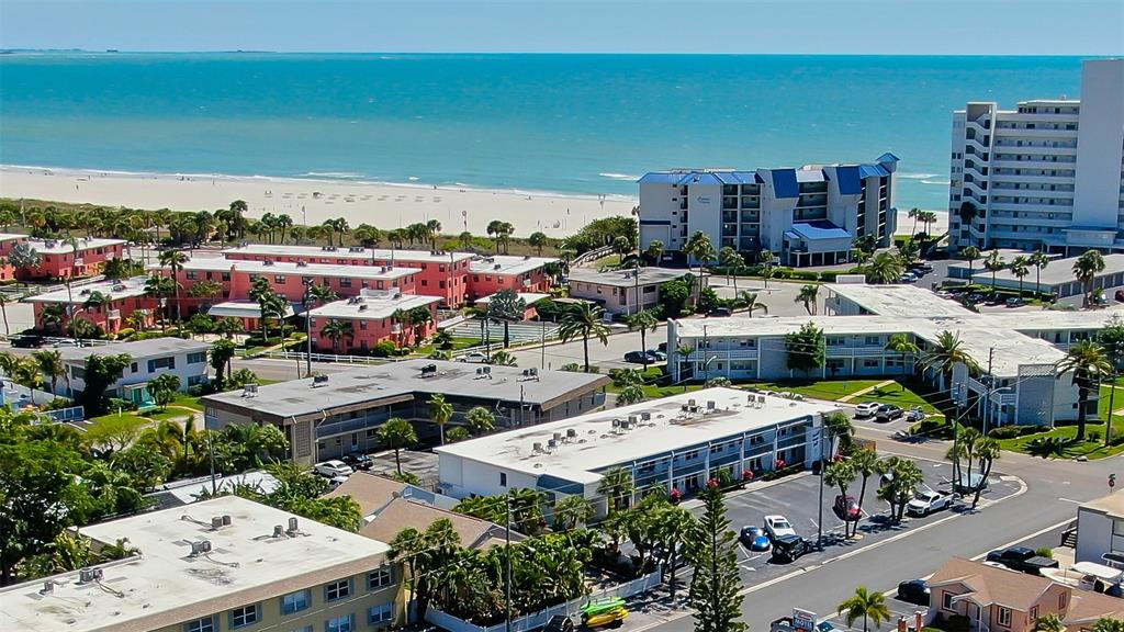 An aerial view shows several multi-story apartment buildings and motels near a sandy beach — 680 71ST AVENUE UNIT 14, ST PETE BEACH, FL