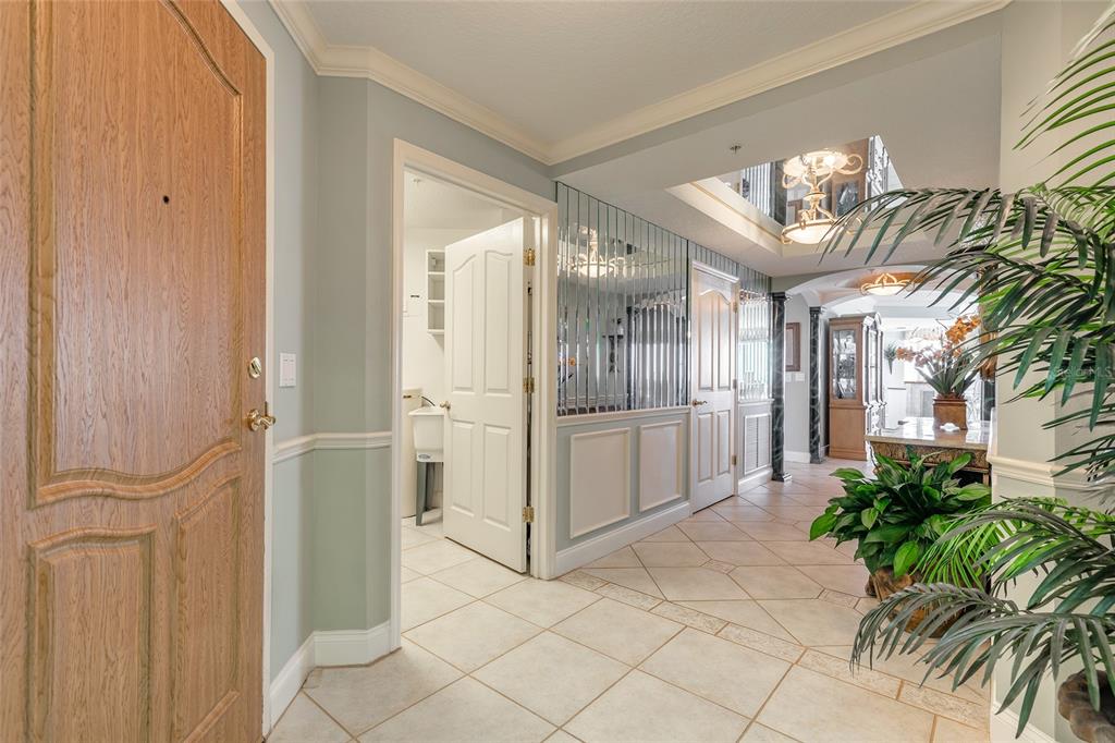 An entryway with tiled floors, a wooden door, mirrored walls, and a view into rooms — 2300 N ATLANTIC AVENUE UNIT 301, DAYTONA BEACH, FL