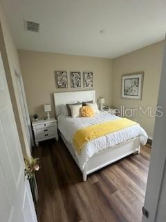 A bedroom features a white bed with yellow bedding, a nightstand, and wall art — 10274 SW 99TH LANE, OCALA, FL